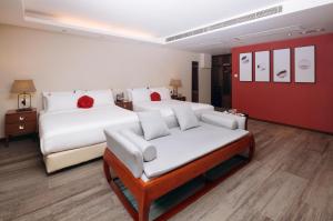a hotel room with two beds and a couch at Butterfly on Wellington, Central in Hong Kong