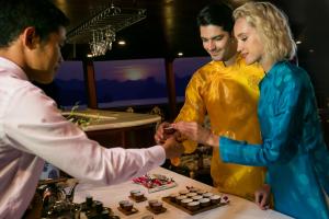 a man handing a woman a piece of chocolate at Emperor Cruises Legacy Ha Long in Ha Long