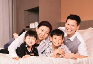 a family laying on a bed posing for a picture at Butterfly on Wellington, Central in Hong Kong
