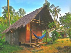 a small hut with a hammock in front of it at Ozone Beach Huts in Ko Lanta