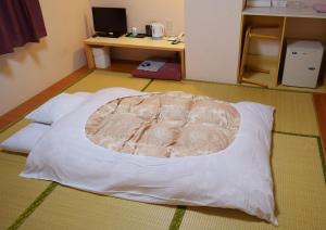 a room with a white bed on the floor at Hotel All In Stay Hakodate in Hakodate