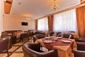 um restaurante com mesas e cadeiras e um lustre em Park Hotel em Krasnodar