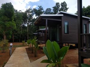 a log cabin with a porch and trees at Pantharee Resort in Krabi