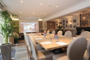 a conference room with a long table and chairs at Hotel Eifelland in Butgenbach