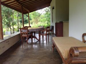 Zimmer mit einem Tisch, Stühlen und einem Fenster in der Unterkunft WildEscape, Yala Blocks 3 & 5 in Buttala