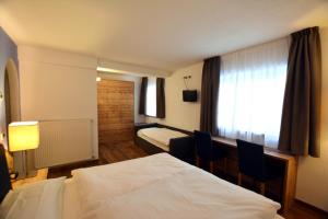 a hotel room with a bed and a window at Hotel Nès Crépes in Pozza di Fassa