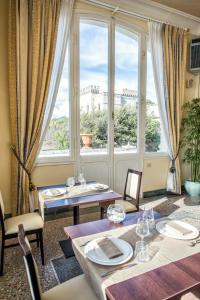 un comedor con mesas y una gran ventana en Villa Parisi Grand Hotel, en Castiglioncello