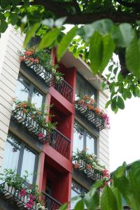 a red building with flower boxes on the windows at Au Coeur d'Hanoi Boutique Hotel in Hanoi