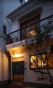 een wit gebouw met een balkon en een deur bij Chikyuutabikazoku USJ in Osaka