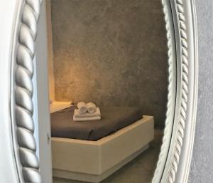 a mirror with two towels on a bed at Philippion Boutique Hotel in Fira