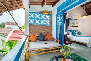 a room with a balcony with a bed and a bed and a window at Local Beach Homestay in Hoi An