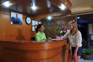 two women standing at a bar with a dog at Island View Bungalows in Choeng Mon Beach