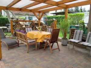 a patio with a table and chairs under a wooden pergola at Ferienhaus in guter Lage in Dresden