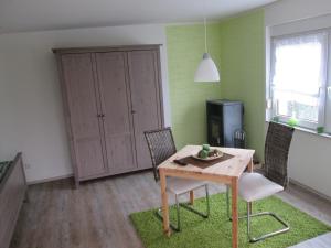 uma sala de jantar com uma mesa e cadeiras e uma televisão em Ferienhaus in guter Lage em Dresden