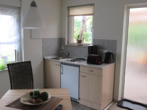 uma cozinha com um lavatório e uma mesa com um prato de frutas em Ferienhaus in guter Lage em Dresden