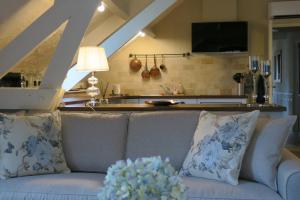 ein Wohnzimmer mit Couch und Küche in der Unterkunft Le Coustal in Auriac-du-Périgord