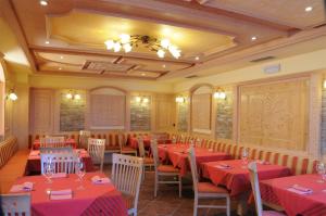 a dining room with red tables and chairs at Hotel Stella in Passo del Tonale