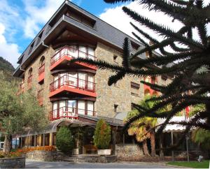 un gran edificio de ladrillo con balcón rojo en Hotel Guillem & Spa, en Encamp