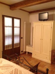 a bedroom with a tv on top of a cabinet at Agriturismo La Collina in Siena