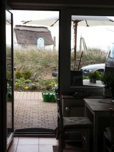 a door to a patio with a view of a yard at Strandhaus Buchtmitte in Haffkrug