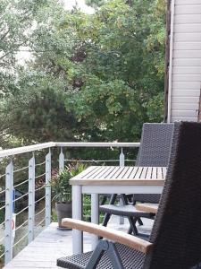 a porch with a table and chairs on a deck at Strandhaus Buchtmitte in Haffkrug