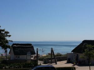 Blick auf einen Strand mit Häusern und das Meer in der Unterkunft Strandhaus Buchtmitte in Haffkrug