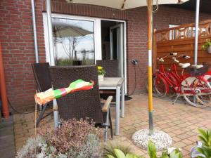 a patio with two chairs and an umbrella at Strandhaus Buchtmitte in Haffkrug