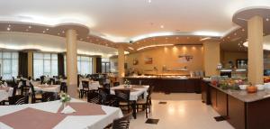 a restaurant with tables and chairs and a bar at Hotel Rеgina - Golden Sands All Inclusive in Golden Sands
