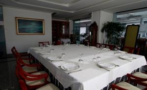 een lange tafel met een witte tafelkleed en stoelen bij Hotel Adelma in Hoznayo