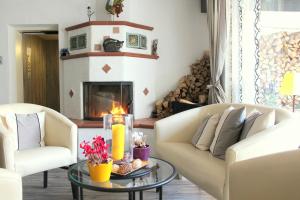 a living room with two couches and a fireplace at Hotel Brandl in Bad Wörishofen