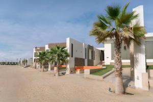 a row of buildings on a beach with palm trees at Tamara Beach Resort, Al Khobar Half Moon Bay-"Families Only" in Half Moon Bay
