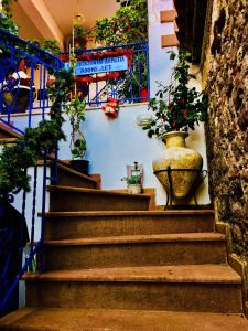 a staircase with two large vases with plants on it at Karagiannaki in Skála Sykaminéas