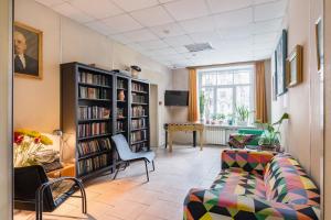 a living room with a couch and a book shelf at Metro-Tour Hostel in Saint Petersburg