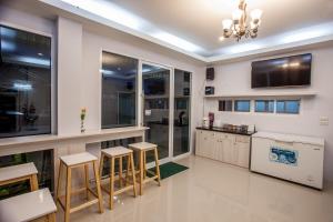 a kitchen with a counter and stools in a room at Lin House in Thalang