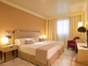 een hotelkamer met een groot bed en een rode stoel bij Vincci Albayzin in Granada