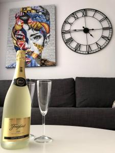Una botella de champán sentada en una mesa con un reloj en Yumbo Apartments, en Maspalomas