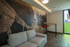 a living room with a couch and a wall with a painting at Citi Hotel's Wrocław in Wrocław