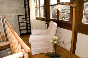 a living room with a white chair and a window at Jakobsturm Ferien im Turm in Röttingen