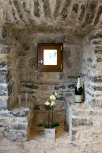 Cette chambre en pierre dispose d'une fenêtre et d'un vase de fleurs. dans l'établissement Jakobsturm Ferien im Turm, à Röttingen