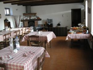 een eetkamer met tafels met rode en witte tafelkleden bij Da Nonna Carla in Alfiano Natta