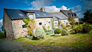 a large brick house with solar panels on it at la lande huel in Saint-Brandan