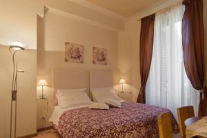sypialnia z łóżkiem z białymi poduszkami i oknem w obiekcie Bed & Bed Peterson we Florencji