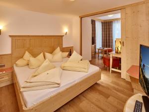 una camera da letto con un letto con lenzuola e cuscini bianchi di Hotel Zum Hirschen a Längenfeld