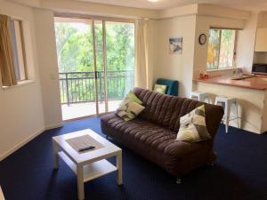 uma sala de estar com um sofá e uma mesa em Gold Coast Family Apartment em Gold Coast