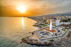 - une vue aérienne sur une plage avec un phare dans l'établissement Apartamento Faro 77, à Torrox Costa