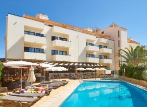 a hotel with a swimming pool with chairs and umbrellas at Oceanus Aparthotel in Albufeira