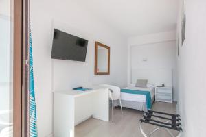 Habitación blanca pequeña con cama y TV en BLUESEA Arenal Tower Adults Only, en El Arenal