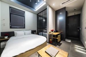 um quarto com uma grande cama branca e uma mesa em Hotel the Artist Dongdaemun em Seul