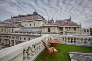 a chair and table on a balcony in front of a building at Callas House in Budapest