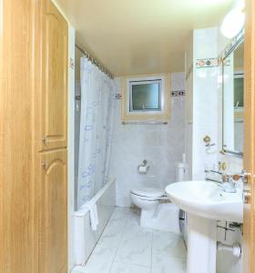 a bathroom with a sink and a toilet and a television at Les Palmiers House in Larnaka